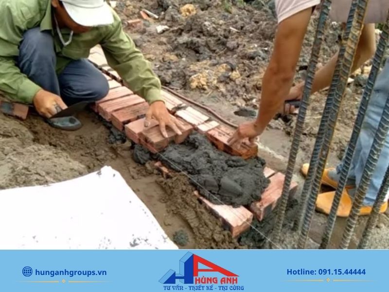Thi công hàng gạch đầu tiên làm móng chuẩn khi xây tường gạch 200